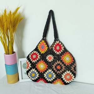Detail of colorful granny square crochet tote bag with vibrant floral stitching