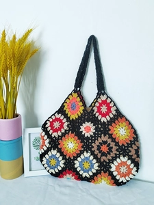 Detail of bohemian handmade crochet tote bag featuring colorful floral granny square patterns