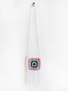 Detailed macro view of handmade crochet square bag with floral motif and long fringe