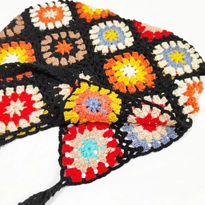 Detail of handmade crochet granny square stitching with multi-colored floral patterns