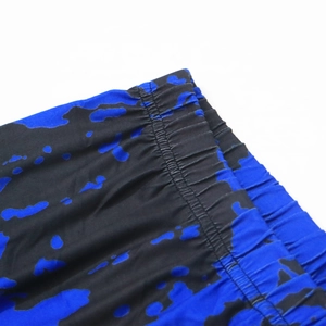 Detail shot of elastic waistband with reinforced stitching on blue tie-dye beach shorts