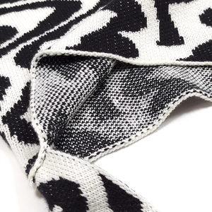 Close-up of black and white wave pattern knit fabric showing thick woven texture and detail