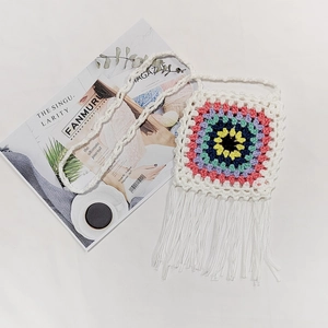Macro shot of colorful crochet granny squares and fringe detail on a cotton crossbody bag