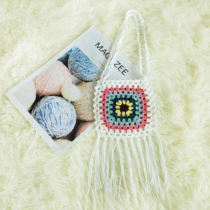 Detail of bohemian crochet crossbody bag with colorful granny square and white tassels