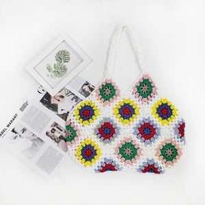 Close-up of handmade crochet tote bag with colorful granny square floral patterns