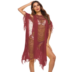 Detail of burgundy crochet beach cover-up featuring hollow-out patterns and long tassels