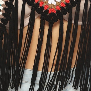 Close-up of handmade crochet bikini top with colorful geometric patterns and long black tassels