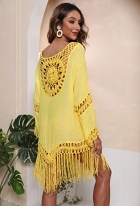 Detail der gelben Häkel-Strandtunika mit kreisförmigem Muster und Boho-Fransensaum