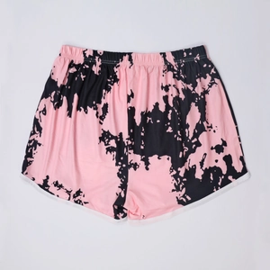 Detail view of tie-dye beach shorts with elastic waistband and contrast white trimming