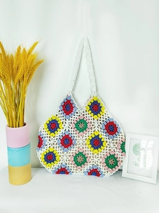 Detail of bohemian hand-crocheted tote bag featuring colorful grandma square floral patterns