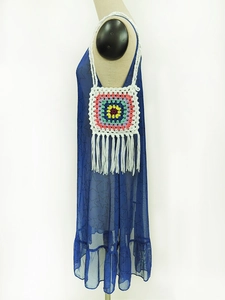 Detail of handmade crochet crossbody bag with granny square pattern and long tassels