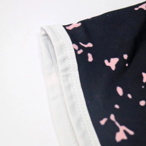Detailed macro view of tie-dye fabric with pink ink splashes and neat white elastic hem