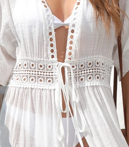 Detail of white lace patchwork beach cover-up with textured fabric and tie closure