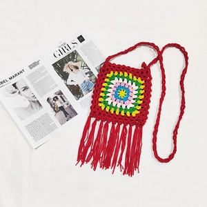 Detail view of handmade crochet bag with colorful granny square and long red fringe