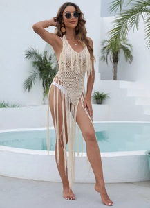Close-up of intricate crochet hollow-out knit patterns and fringe tassels on a beach cover-up