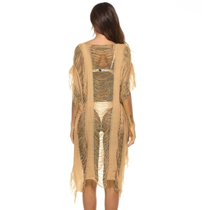 Detail of hollow-out knit beach cover-up with long tassels and open-knit texture back