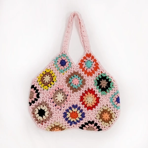 Detail of colorful crochet granny squares on a handmade pink cotton tote shoulder bag