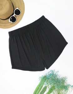 Flat lay of black ribbed high waist lounge shorts with summer beach holiday accessories