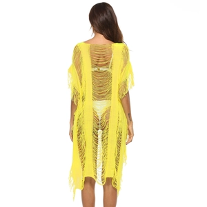 Detail view of bright yellow crochet knit beach cover-up with long tassels and openwork
