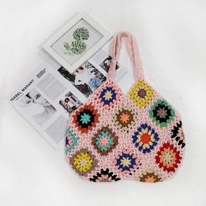 Detail of colorful crochet flower patches on a bohemian handmade knitted tote bag