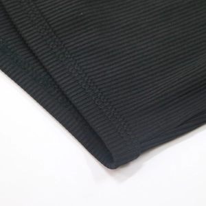 Detail view of black ribbed knit fabric showing fine texture and double-needle stitching