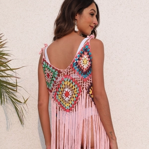 Detail of colorful crochet grandmother square pattern and long tassels on back of dress