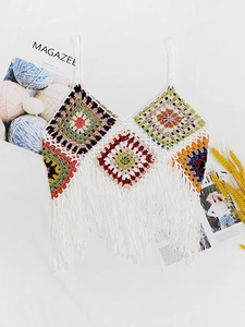 Detail of bohemian handmade crochet crop top featuring colorful patchwork and white fringe