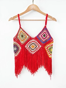 Detailed view of handmade crochet top featuring colorful granny squares and red tassels