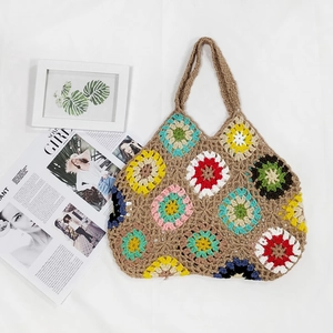 Detailed close-up of colorful crochet flower patterns on the woven tote bag surface