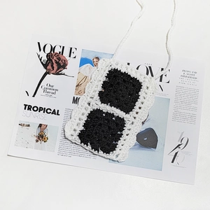 Handmade crochet crossbody phone bag with black and white granny square pattern design