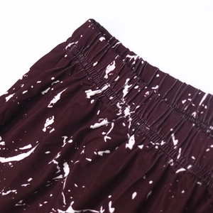 Close-up of elastic waistband on dark tie-dye beach shorts with fine stitching detail