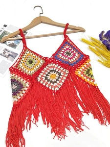 Detail of handmade crochet crop top with colorful granny squares and red fringe tassels