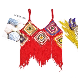 Detailed close-up of handmade crochet vest featuring colorful granny square patterns and red tassels