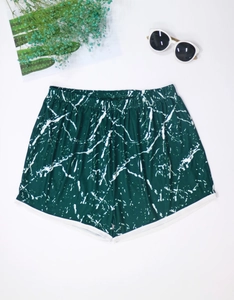 Detailed flat lay of women's forest green marble print beach shorts with white piping
