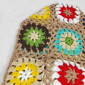 Detailed macro view of colorful crochet granny square patterns on a handmade tote bag