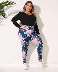 Detail of plus size floral leggings and black long sleeve shirt on female model