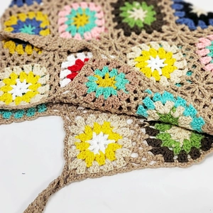 Close-up of handmade crochet bag showing colorful floral granny square patterns
