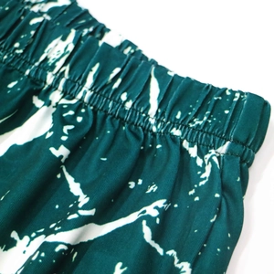 Macro detail of the elastic waistband and tie-dye print on beach shorts for women