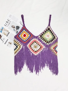 Detail of colorful granny square crochet stitches and purple tassels on the boho top