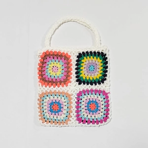 Detailed view of handmade granny square crochet patterns on a colorful tote bag