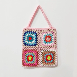 Detail of colorful granny square crochet patterns on a handmade bohemian shoulder bag