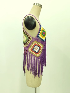 Detail of bohemian handmade crochet vest featuring colorful granny squares and long tassels