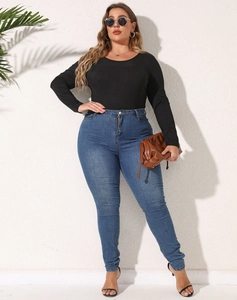 Detail eines Langarm-Bodys in Übergröße kombiniert mit blauer High-Waist-Skinny-Jeans