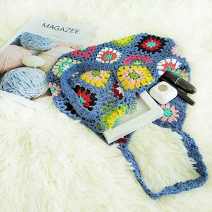Detailed close-up of handmade crochet bag featuring colorful floral granny square patterns