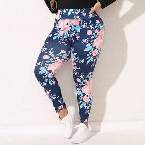 Close-up of high-waisted floral leggings with pink and blue flower prints on navy background
