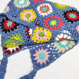 Close-up of bohemian crochet handbag with colorful granny square floral patchwork patterns