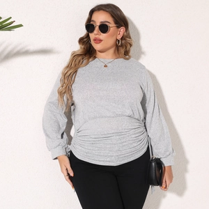 Detail of adjustable drawstring waist and pleated texture on gray oversized sweatshirt