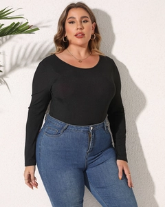 Detail eines schwarzen gerippten Langarm-Bodys kombiniert mit blauer Denim-Jeanshose