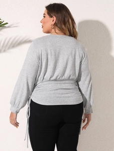 Detail of adjustable pleated waist design on grey oversized casual sweatshirt for women