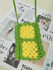 Detailed close-up of handmade crochet bag featuring bright green and yellow floral motifs